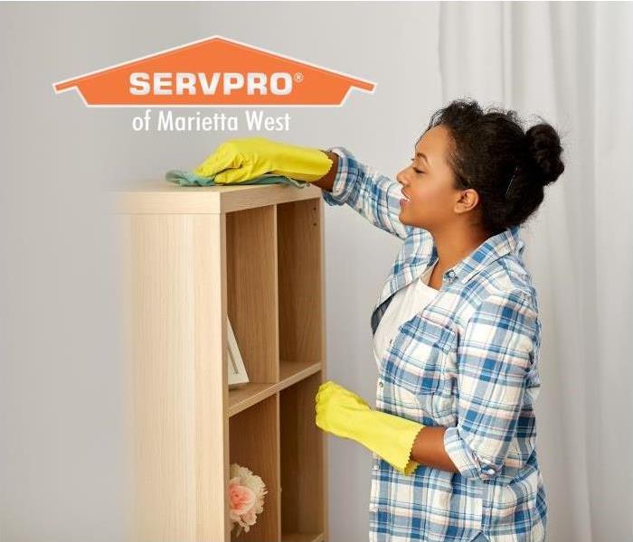 Woman cleaning bookshelf in home