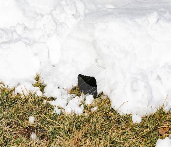 snow on grass with down spout covered with snow