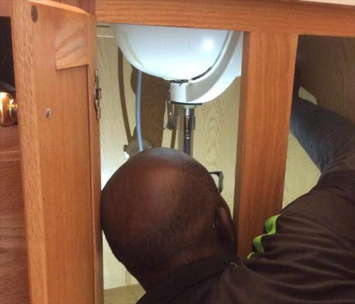 SERVPRO technician inspecting sink for water damage
